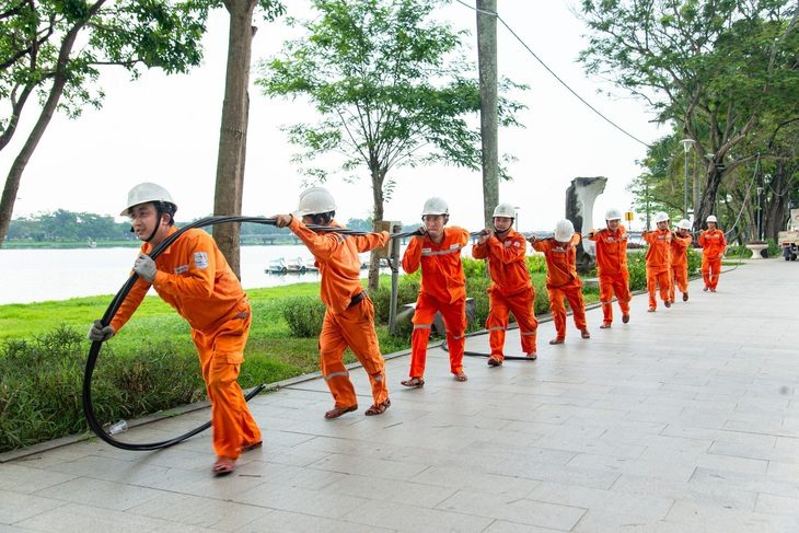 Công nhân Điện lực Thừa Thiên Huế kéo dây điện chuẩn bị cho lễ hội Festival 2024 - Ảnh: EVNCPC cung cấp